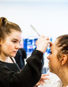 University Centre Leeds student doing another student's eyebrows