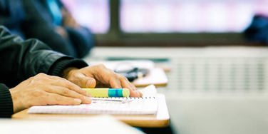 hand and notepads on a desk