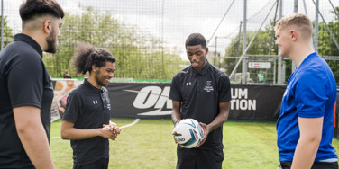 University Centre Leeds sport students holding a football