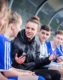 sport students sat in a football dugout