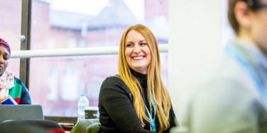 University Centre Leeds student smiling at their desk