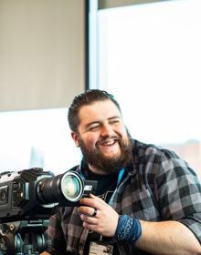 student stood with camera preparing to film 