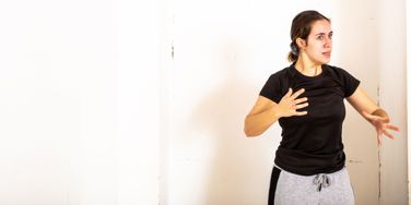 Acting student sat in room, arms raised