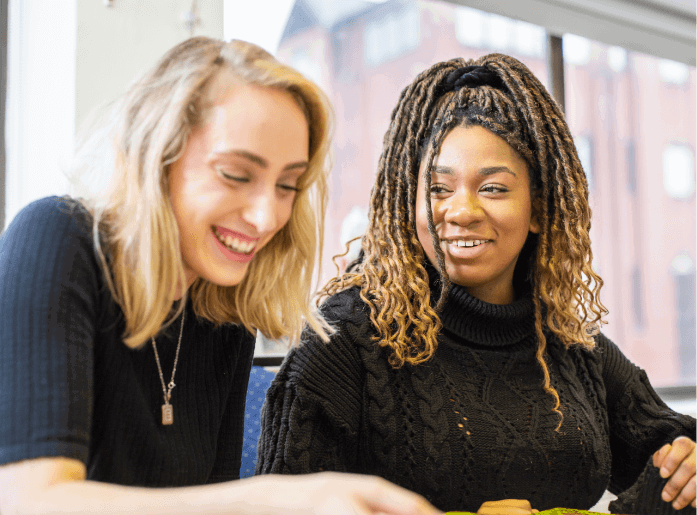 two students smile looking down