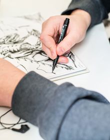 student drawing in notebook at a desk 