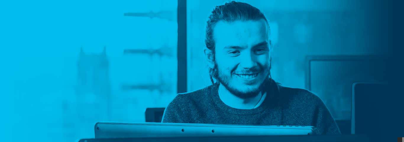 student smiling at a monitor, blue overlay