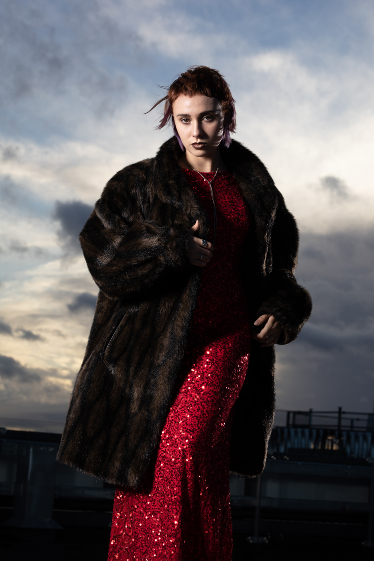 person in red dress with mink style coat