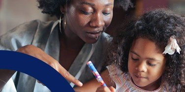 person look down at a toddler drawing a picture