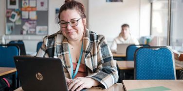 student with a chromebook at a desk