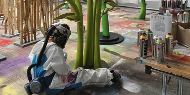 University Centre Leeds student spray painting large prop flower