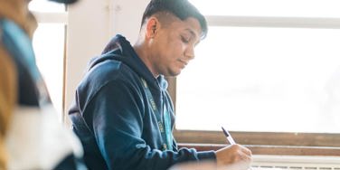 student at a desk writing