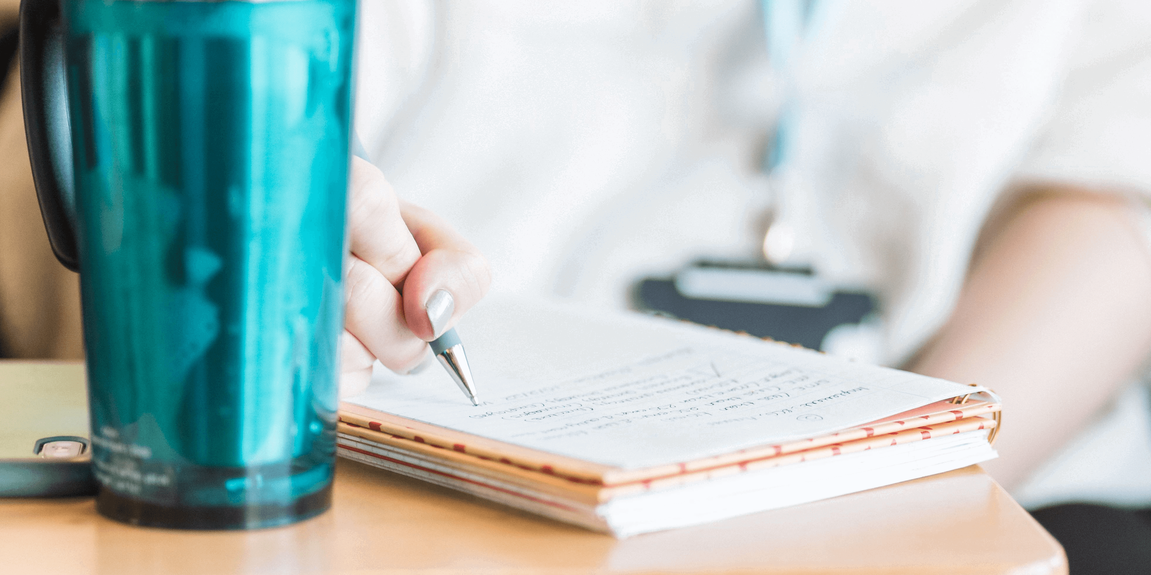 hot drink flask next to a book with someone's hand writing