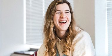 Student working at desk smiling 