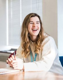 Student working at desk smiling 