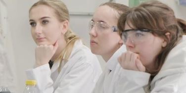 people sat in lab coats in a lab