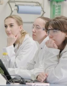 people sat in lab coats in a lab