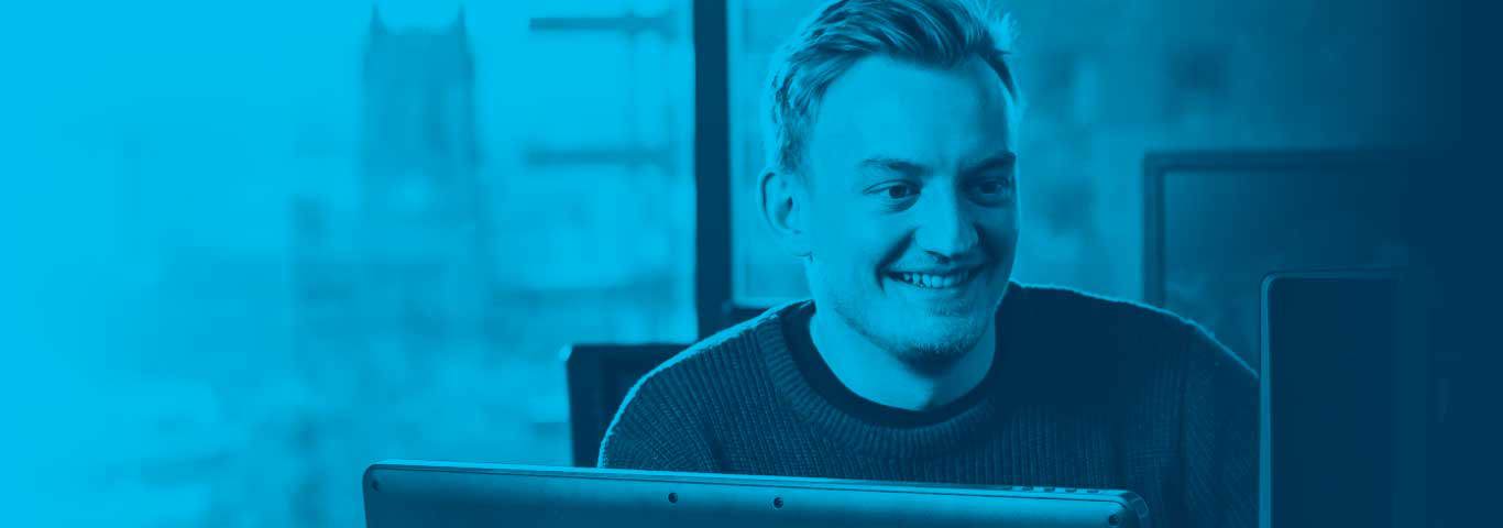 student smiling at a monitor, blue overlay