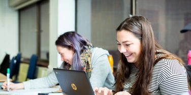 Students smile at chromebooks while working