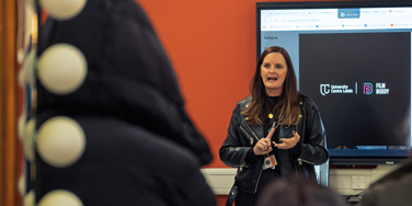 Tutor giving open day talk in bright modern room
