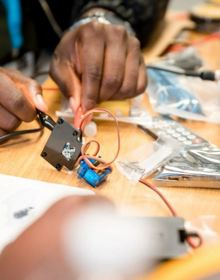 hands touching a servo motor with crocodile clips